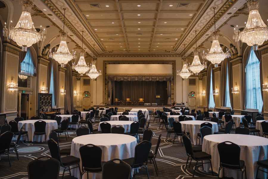 Grand ballroom with chandeliers and round tables set for a corporate casino night