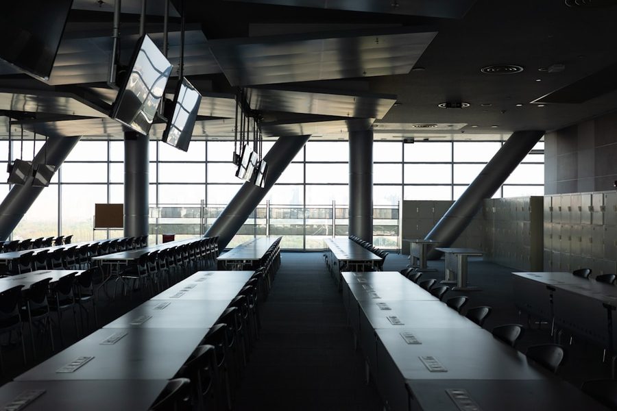 Conference hall with long tables and screens ready for a team-building rotation