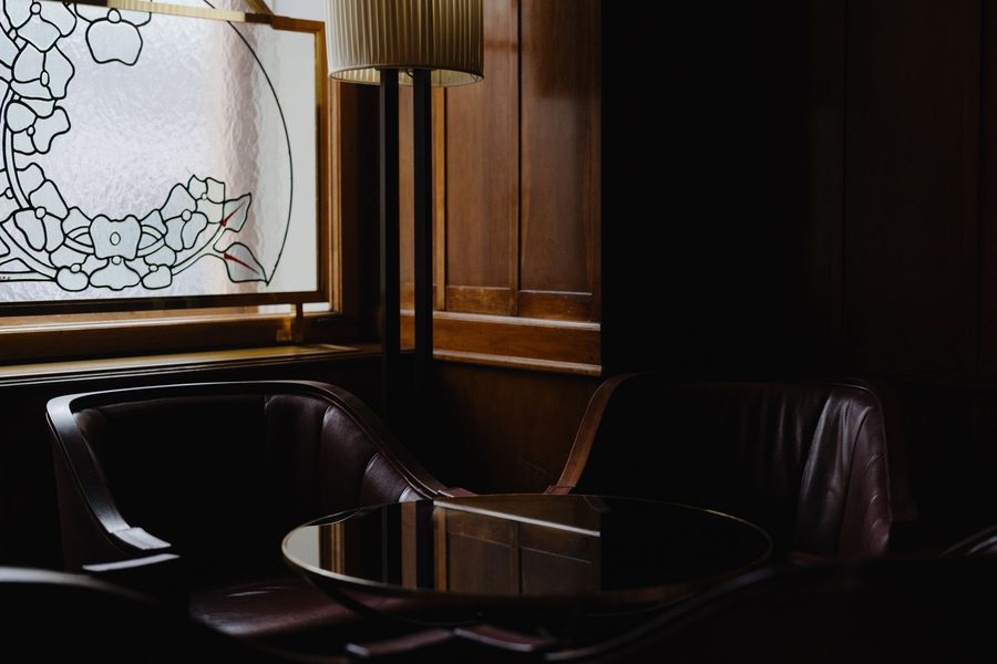 Dark leather armchairs and stained glass in a classic lounge — the VIP evening register