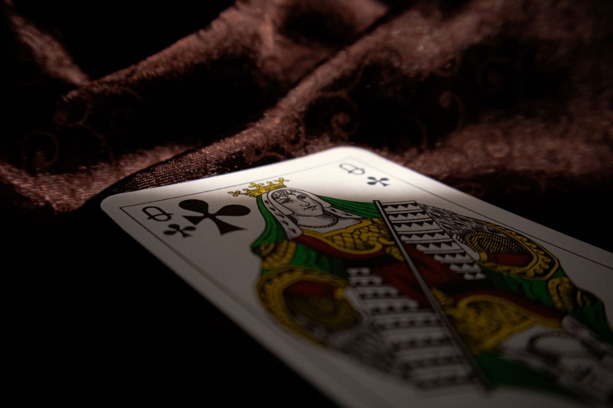 Close-up of the queen of clubs from the PromoLineup house deck on dark fabric