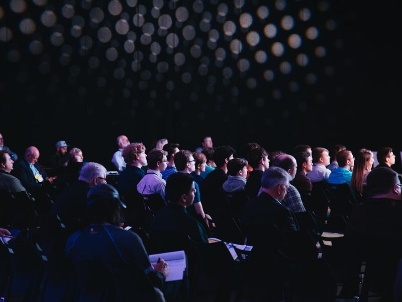 Conference audience seated before the closing table rotation